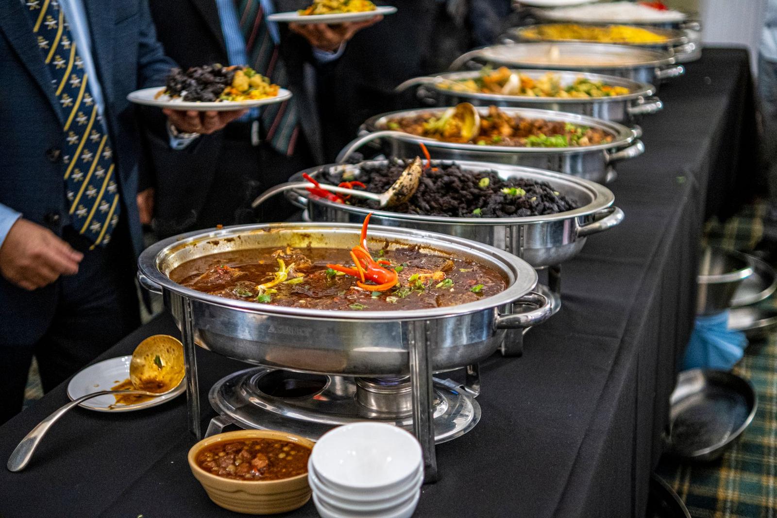 People Standing over Table with Food